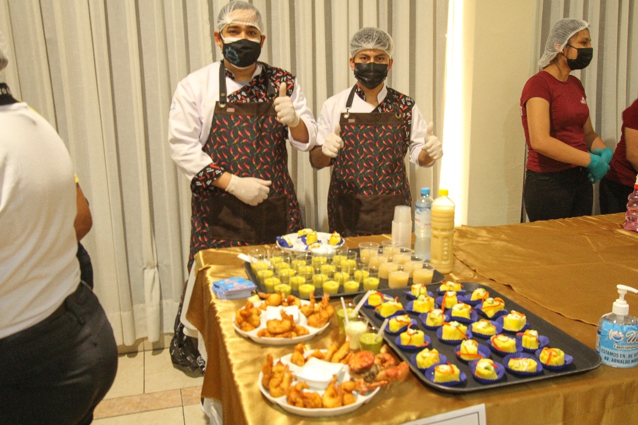 Foto de dos representantes de restaurante que recibió certificado de Restaurante Saludable presentando sus platos