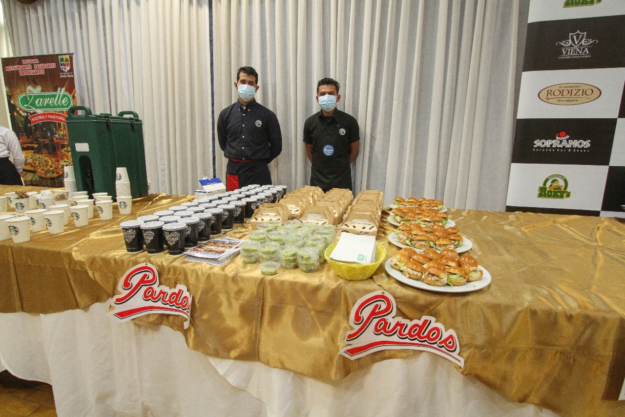 Foto de dos representantes de restaurante Pardos que recibió certificado de Restaurante Saludable presentando sus platos