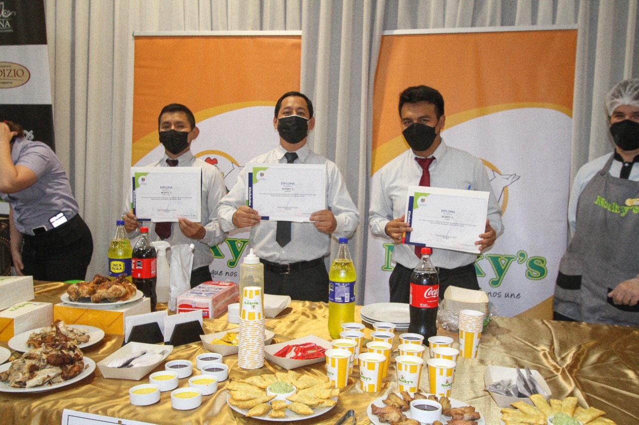 Foto de tres representantes de restaurante Norkys que recibió certificado de Restaurante Saludable exhibiendo sus certificados