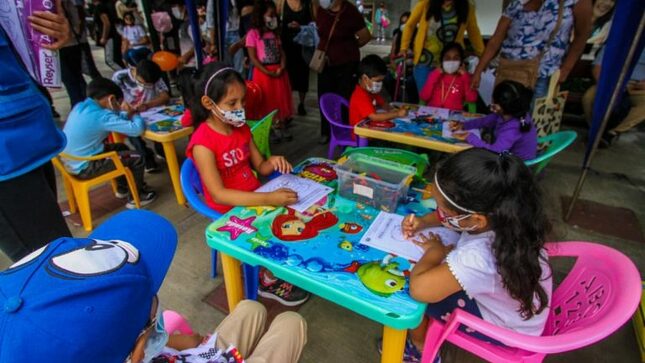 Dos niñas de colegio público del Distrito de Jesús María coloreando en material didáctico ofrecido por la Biblioteca Viajera
